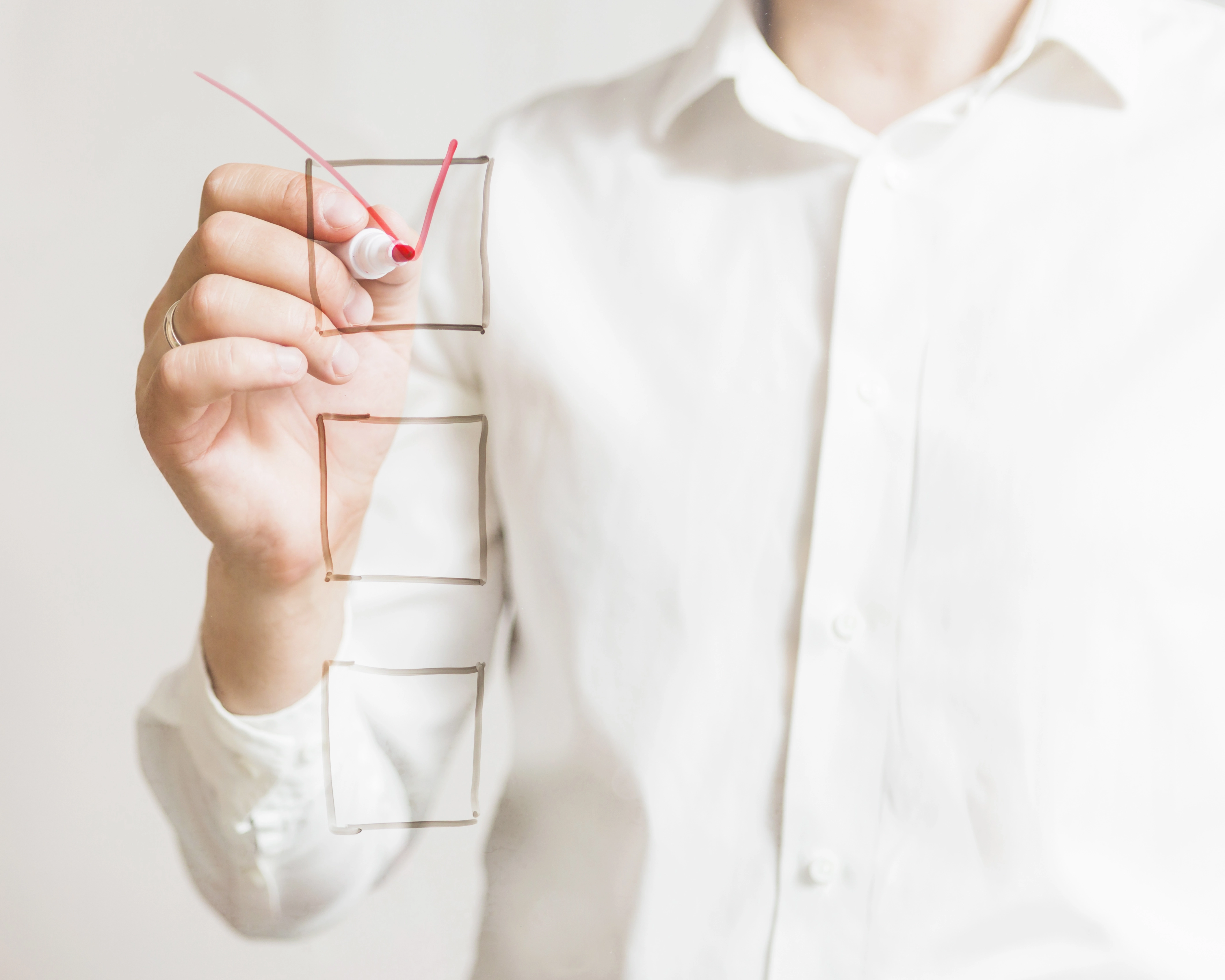 businessperson-s-hand-marking-check-box-with-red-marker-screen.webp